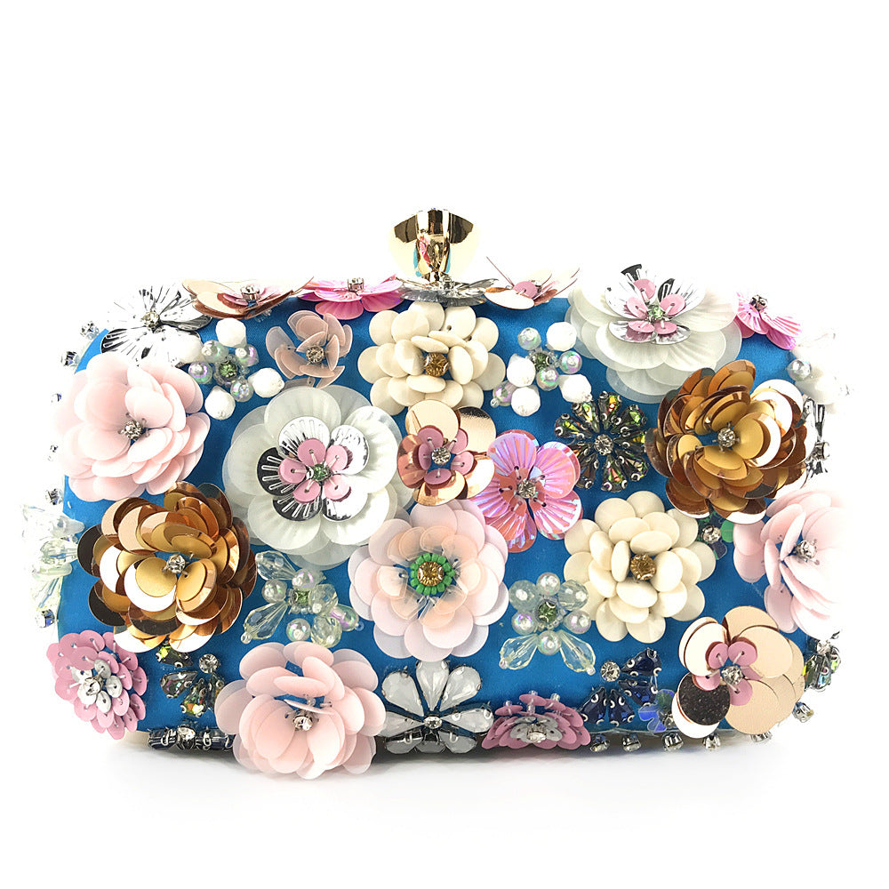 Blue box clutch bag covered in 3D sequin and beaded flowers in pink, cream, gold and lilac with gold-tone clasp